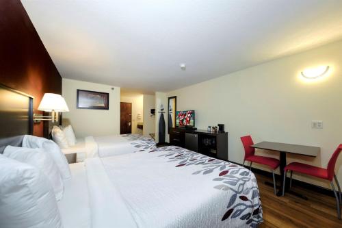 a hotel room with two beds and a desk at Red Roof Inn Osage Beach - Lake of the Ozarks in Osage Beach