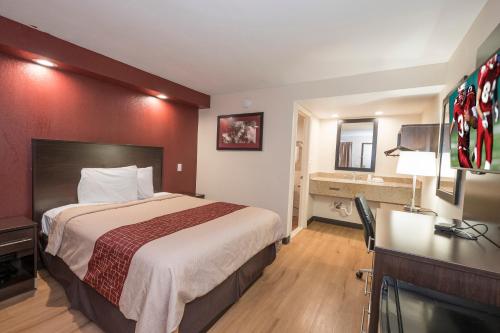 a hotel room with a bed and a desk at Red Roof Inn Wildwood – Cape May/Rio Grande in Rio Grande