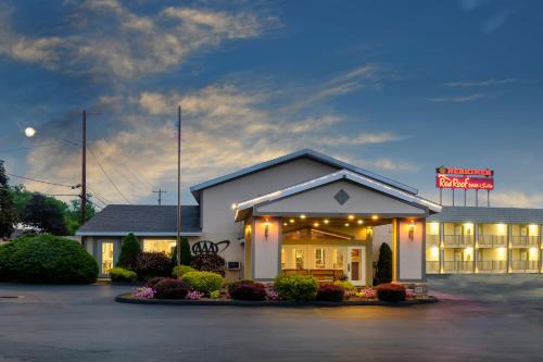 a building with a sign in a parking lot at Red Roof Inn and Suites Herkimer in Herkimer