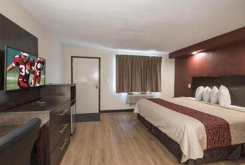 a hotel room with a bed and a flat screen tv at Red Roof Inn Wildwood – Cape May/Rio Grande in Rio Grande
