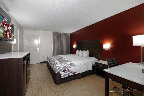 a hotel room with a bed and a desk at Red Roof Inn Gadsden in Gadsden