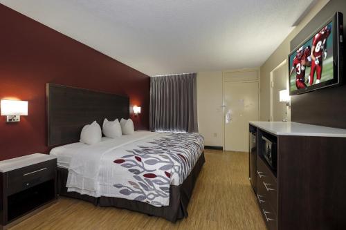 a hotel room with a bed and a flat screen tv at Red Roof Inn Gadsden in Gadsden