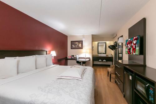 a hotel room with a large bed and a desk at Red Roof Inn PLUS + Boston - Framingham in Framingham