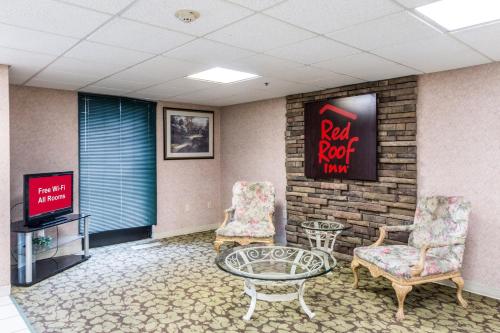 a waiting room with two chairs and a table and a tv at Red Roof Inn Morehead in Morehead