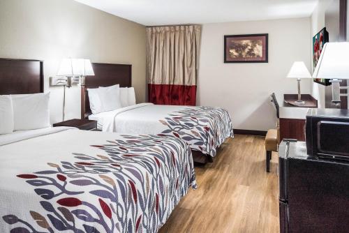 a hotel room with two beds and a television at Red Roof Inn Spartanburg - I-26 in Spartanburg