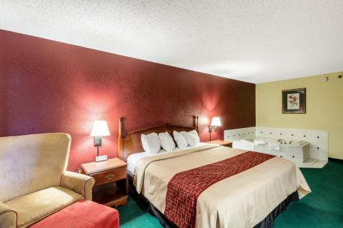 a hotel room with a bed and a chair at Red Roof Inn Morehead in Morehead
