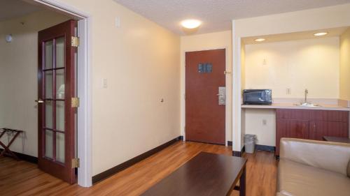 an empty living room with a door and a kitchen at Red Roof Inn & Suites Indianapolis Airport in Indianapolis