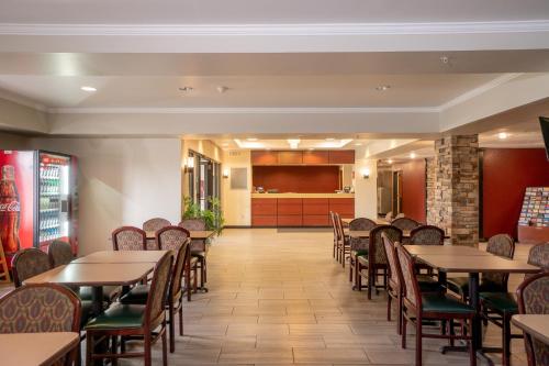 a dining room with tables and chairs at Red Roof Inn & Suites Indianapolis Airport in Indianapolis