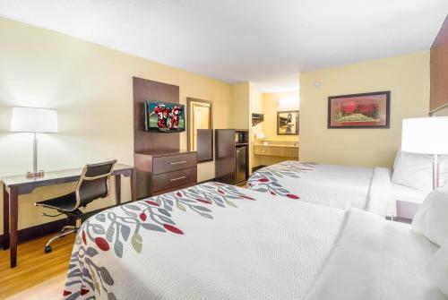 克拉克斯維爾的住宿－克拉克斯維爾紅屋頂旅館，酒店客房配有两张床和一张书桌