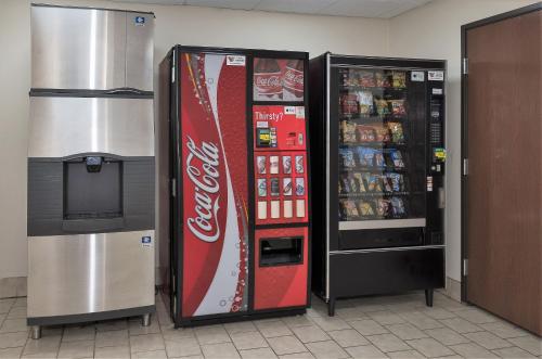 a cocacola soda machine next to a refrigerator at Red Roof Inn Hartford- New Britain in New Britain