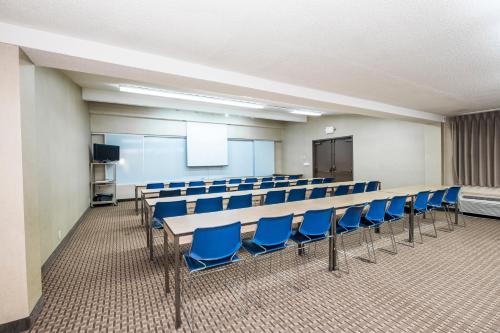 a conference room with blue chairs and a screen at Red Roof Inn & Suites Cincinnati North-Mason in Mason