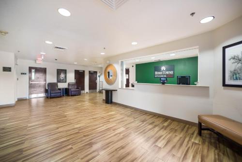 a large lobby with a waiting room with wooden floors at HomeTowne Studios by Red Roof St. Louis - Airport/N Lindbergh in Hazelwood