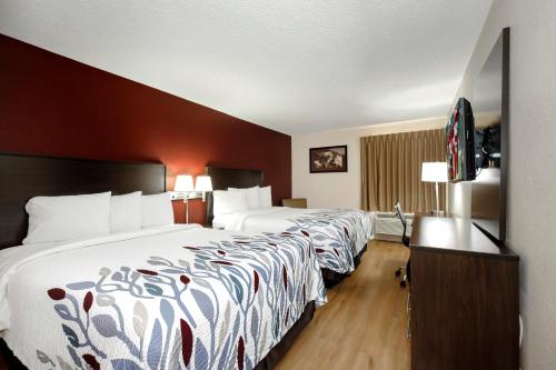 a hotel room with two beds and a television at Red Roof Inn Hillsville in Hillsville