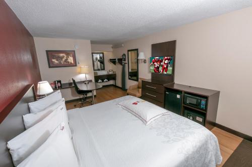 a bedroom with a large white bed and a desk at Red Roof Inn PLUS+ Baltimore North - Timonium in Timonium