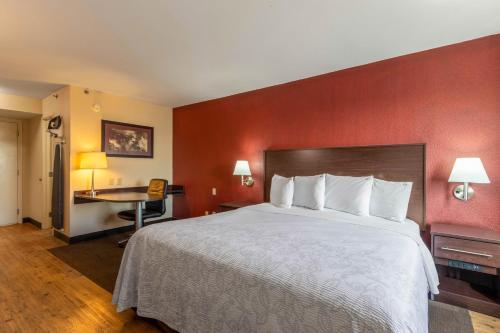 a hotel room with a large bed and a desk at Red Roof Inn PLUS+ El Paso East in El Paso