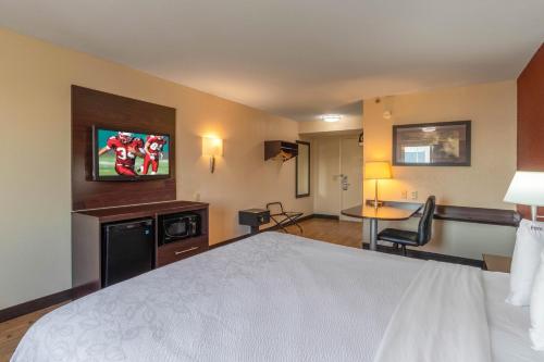 a hotel room with a bed and a television at Red Roof Inn PLUS+ El Paso East in El Paso