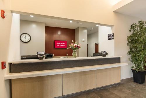a waiting room with a reception desk and a clock at Red Roof Inn Panama City in Panama City