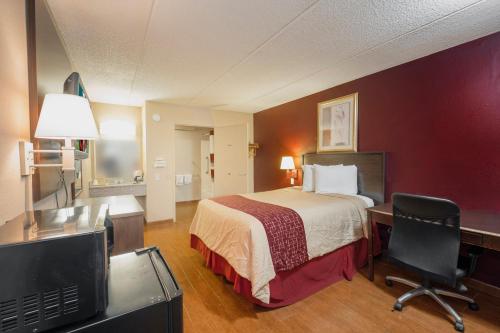 a hotel room with a bed and a desk at Red Roof Inn Jackson Downtown - Fairgrounds in Jackson