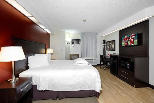 a hotel room with a large bed and a desk at Red Roof Inn PLUS+ Palm Coast in Palm Coast