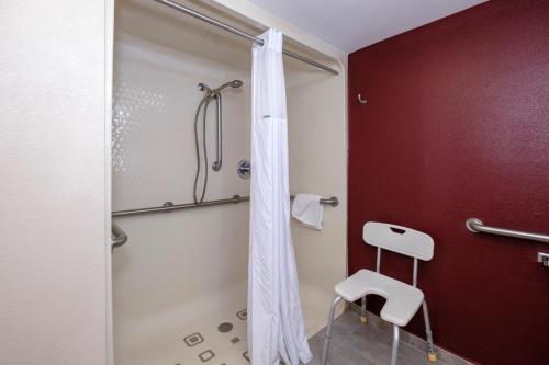 a bathroom with a shower and a white stool at Red Roof Inn PLUS+ Palm Coast in Palm Coast