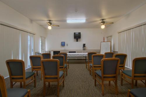 una habitación con filas de sillas y una mesa blanca en Mariposa Inn, en Victorville