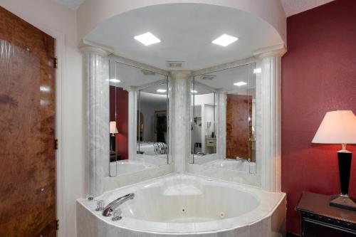 Habitación con bañera grande y espejo grande. en Red Roof Inn & Suites Oxford en Oxford