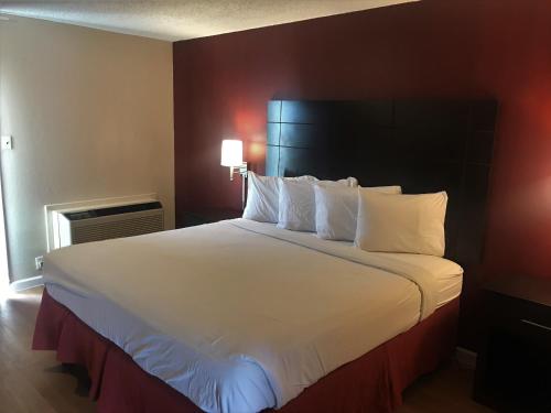 uma grande cama branca num quarto de hotel em Red Roof Inn & Suites San Angelo em San Angelo