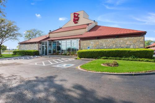 a building with a red roof and a parking lot at Red Roof Inn Columbus - Grove City in Grove City