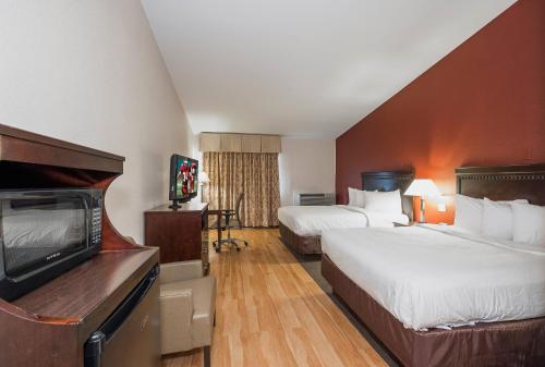 a hotel room with two beds and a flat screen tv at Red Roof Inn & Suites Mt Holly - McGuire AFB in Westampton Township