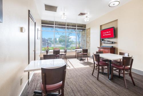 a dining room with tables and chairs and a tv at Red Roof Inn Columbus - Grove City in Grove City