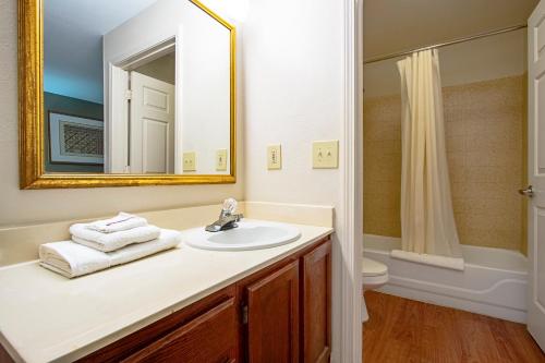 een badkamer met een wastafel, een spiegel en een toilet bij HomeTowne Studios by Red Roof Phoenix - Black Canyon Highway in Phoenix