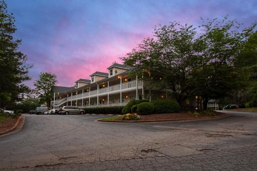 a building with a parking lot in front of it at HomeTowne Studios by Red Roof Atlanta – Lawrenceville in Lawrenceville