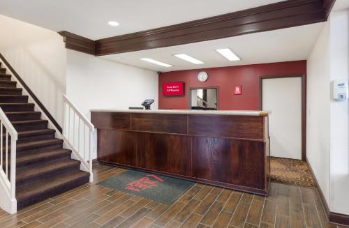 a lobby with a reception desk and stairs at Red Roof Inn Fort Wayne in Fort Wayne