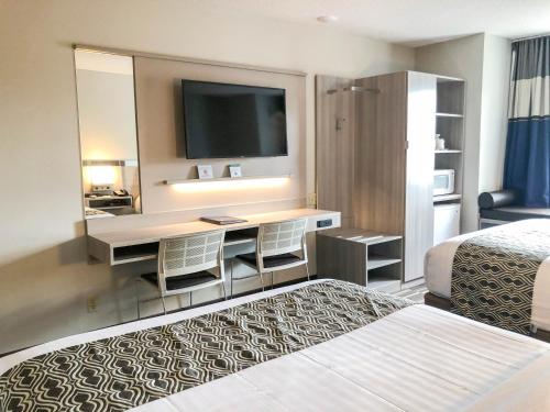 a hotel room with a desk and a television at Microtel Inn & Suites by Wyndham Eagan/St Paul in Eagan