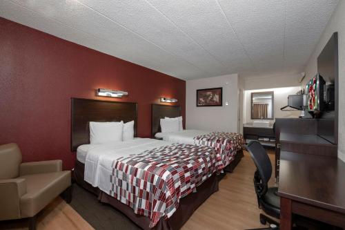 a hotel room with two beds and a desk at Red Roof Inn Washington DC-Lanham in Lanham