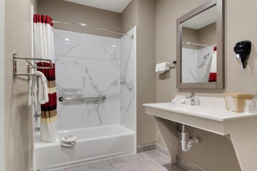 a bathroom with a shower and a sink at Red Roof Inn PLUS + Galveston - Beachfront in Galveston