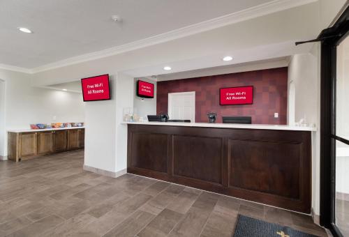 a waiting room with a counter and signs on the wall at Red Roof Inn PLUS + Galveston - Beachfront in Galveston