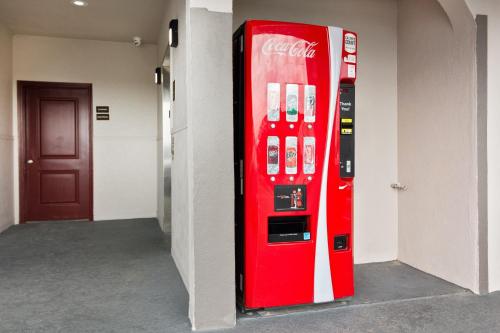 a red cocacola machine in a hallway with a door at Red Roof Inn PLUS + Galveston - Beachfront in Galveston