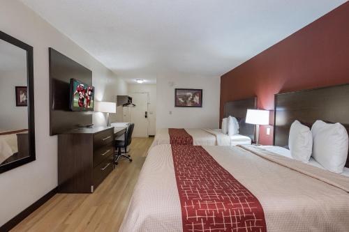 a hotel room with two beds and a desk at Red Roof Inn Dayton Huber Heights in Dayton