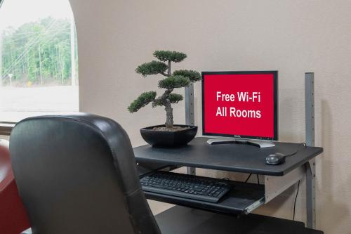 a desk with a computer monitor and a keyboard and mouse at Red Roof Inn & Suites Rome in Rome