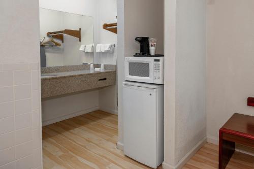 a kitchen with a microwave on top of a refrigerator at Red Roof Inn & Suites Rome in Rome