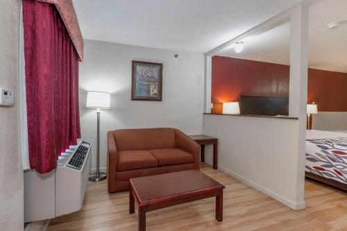 a hotel room with a chair and a bed at Red Roof Inn & Suites Rome in Rome