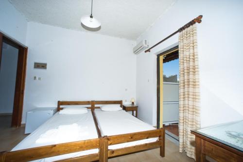 a bedroom with a bed in a room with a window at Rooms Leonidas in Kissamos