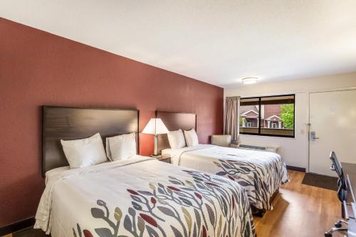 ein Hotelzimmer mit 2 Betten und einem Fenster in der Unterkunft Red Roof Inn Milwaukee Airport in Oak Creek