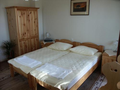 een slaapkamer met een groot bed met een houten frame bij Pri Lazarju Farm Stay in Podgrad