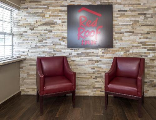 two chairs in a waiting room with a red rock motel sign at Red Roof Inn Chipley in Chipley