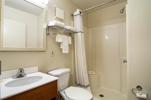 a bathroom with a sink and a toilet and a shower at HomeTowne Studios by Red Roof Chicago - Waukegan in Waukegan