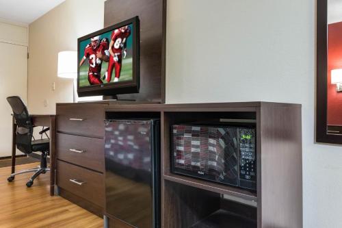 a room with a tv and a entertainment center with a desk at Red Roof Inn Cincinnati Airport–Florence/ Erlanger in Erlanger