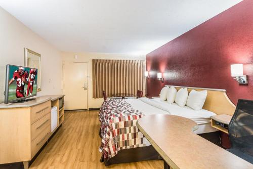 a hotel room with a bed and a flat screen tv at Red Roof Inn Williamsburg in Williamsburg