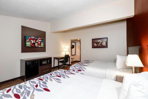 a hotel room with two beds and a desk at Red Roof Inn Vermillion - U of South Dakota in Vermillion